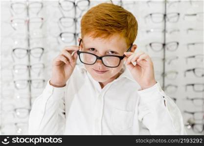 smiling boy with freckle his face wearing spectacle looking camera