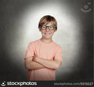 Smiling boy with glasses over a gray background