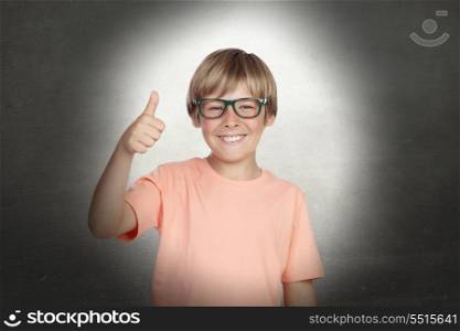 Smiling boy with glasses saying Ok on a over gray background