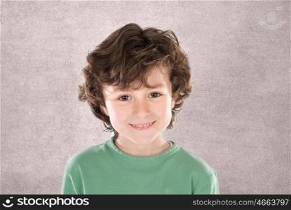 Smiling boy with six years old looking at camera on a grey background