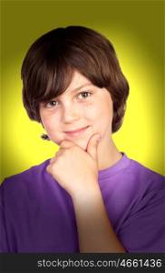 Smiling boy with the hand on his chin on yellow background