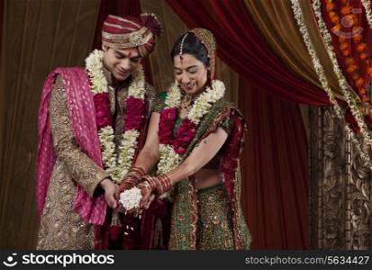 Smiling bride and bridegroom during traditional ceremony