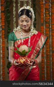 Smiling bride holding kalash