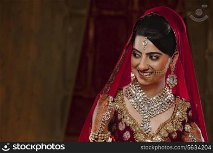 Smiling bride in traditional clothing and jewelry