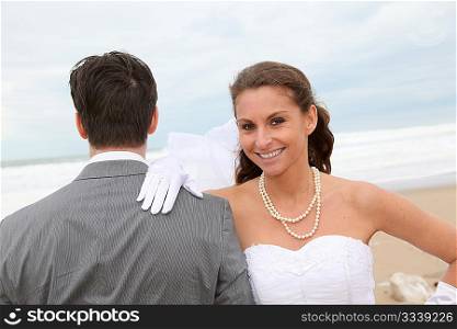 Smiling bride standing on a sandy beach