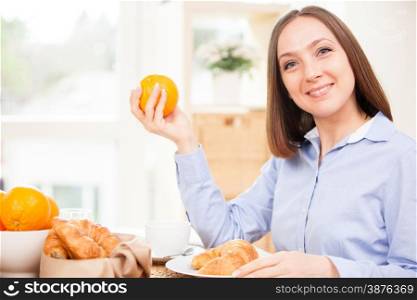 Smiling brunette businesswoman is having healthy breakfast at home