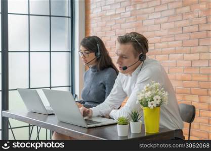 Smiling business blonde, white couple people working call center online from home with headset and computer notebook laptop on webcam video call conference in quarantine. Executive partner agent team.