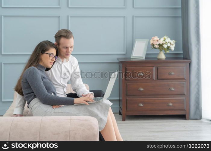 Smiling business blonde, white couple people working online from home on sofa with computer notebook laptop on webcam video call conference in quarantine. Caucasian in family concept.