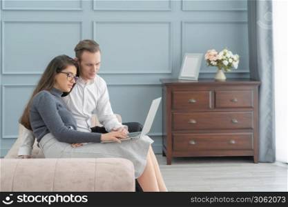 Smiling business blonde, white couple people working online from home on sofa with computer notebook laptop on webcam video call conference in quarantine. Caucasian in family concept.