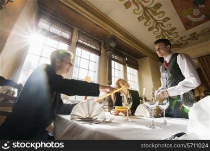 Smiling business couple ordering food at restaurant table