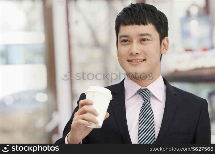 Smiling business man holding coffee cup