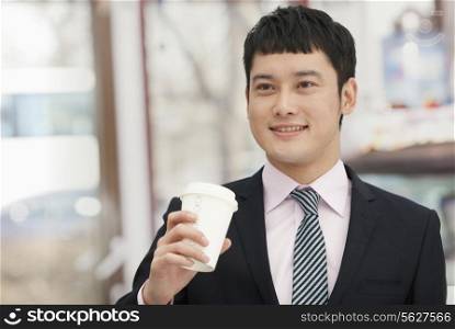 Smiling business man holding coffee cup