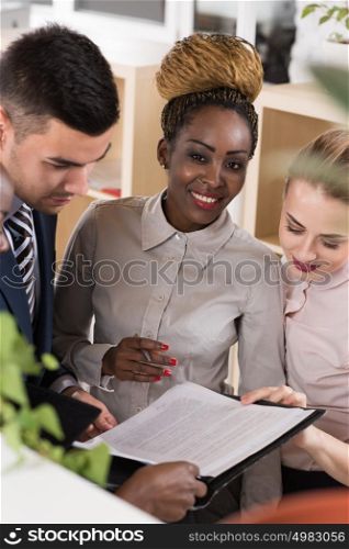 Smiling business team discussing documents and reports at office