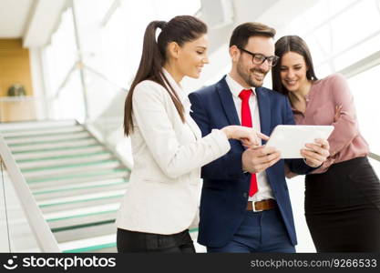 Smiling business team working on tablet pcs in office