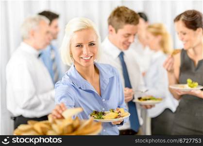 Smiling business woman during company lunch buffet hold salad plate