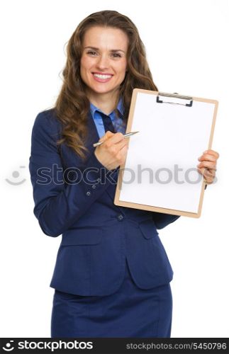 Smiling business woman pointing in blank clipboard