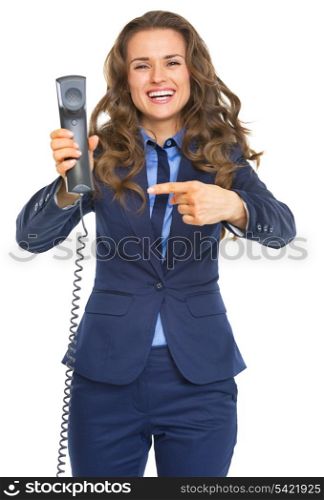Smiling business woman pointing on phone handset