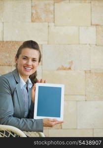 Smiling business woman showing tablet PC