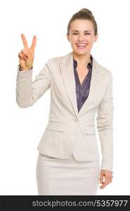 Smiling business woman showing victory gesture