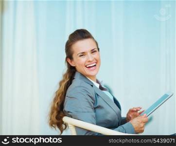 Smiling business woman using tablet pc on terrace
