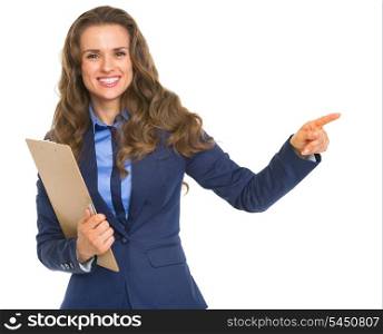 Smiling business woman with clipboard pointing on copy space
