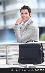 Smiling businessman and briefcase