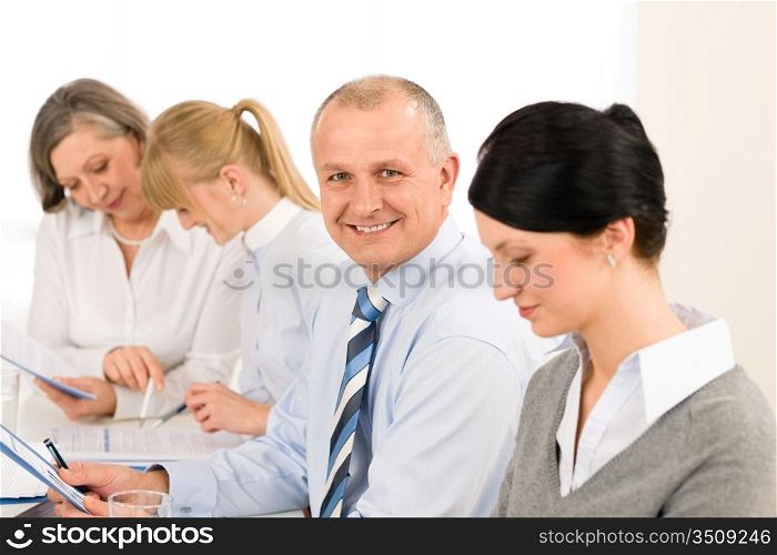 Smiling businessman during meeting with team colleagues