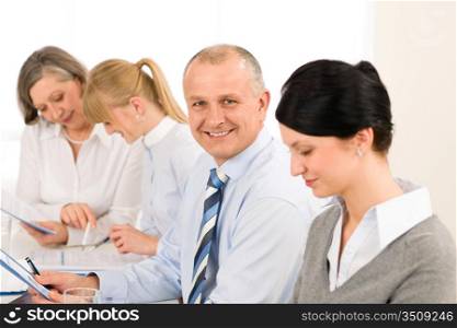 Smiling businessman during meeting with team colleagues