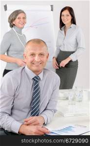 Smiling businessman during team meeting with colleagues give presentation