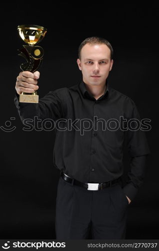 smiling businessman in black shirt with win cup in hand