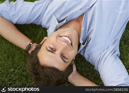 Smiling Businessman Lying Down on Grass