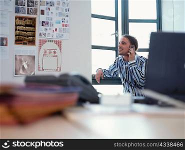 Smiling businessman on phone in office