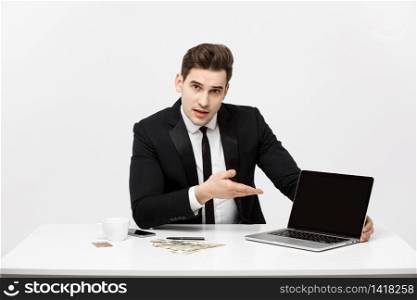 Smiling businessman presenting his laptop computer to the viewer with a blank screen with copy space.. Smiling businessman presenting his laptop computer to the viewer with a blank screen with copy space