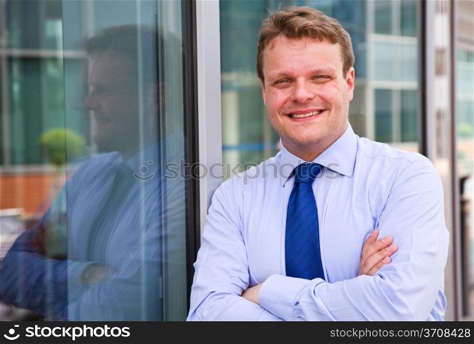 Smiling businessman standing outside a building