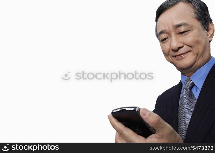 Smiling businessman using cell phone over white background