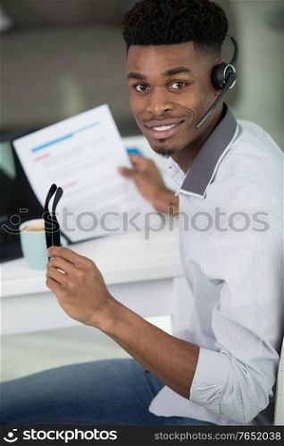 smiling businessman with headset interacting in his office