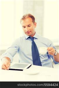 smiling businessman with tablet pc drinking coffee in office