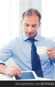 smiling businessman with tablet pc drinking coffee in office. businessman with tablet pc and coffee in office