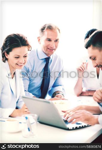 smiling businessman with team on meeting in office