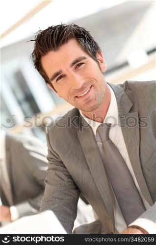 Smiling businessman working on laptop computer