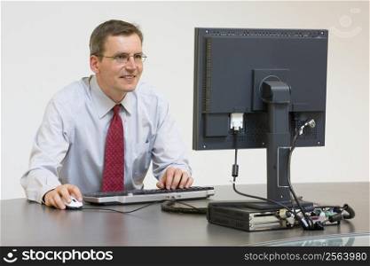 Smiling businessman working with computer in an office