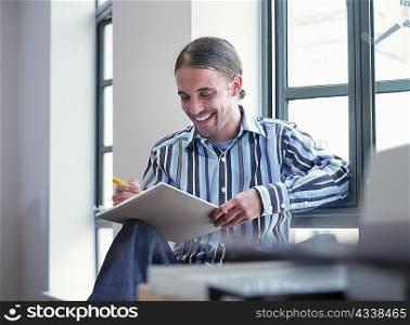Smiling businessman writing in office
