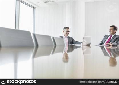 Smiling businessmen talking in conference room