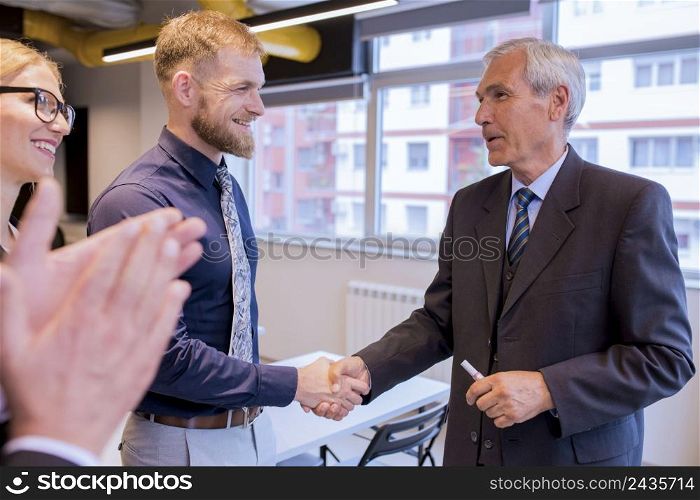 smiling businesspeople shaking hands during meeting office