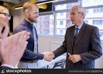 smiling businesspeople shaking hands during meeting office