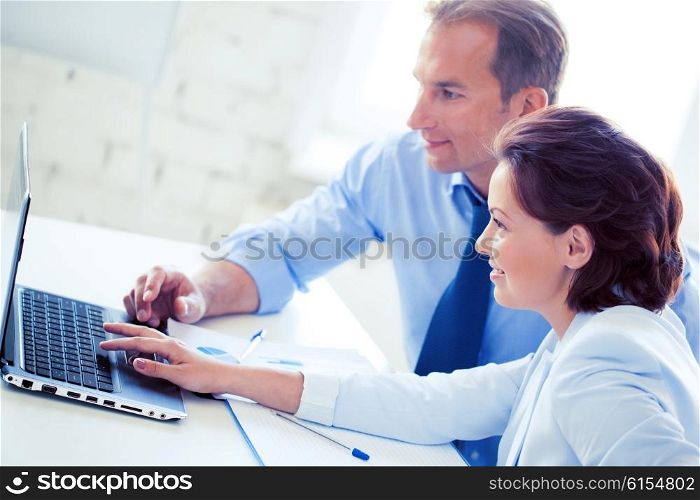 smiling businesswoman and businessman working with laptop in office. man and woman working with laptop in office