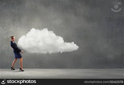 Smiling businesswoman carrying big cloud in hands. Computing concept