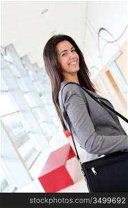 Smiling businesswoman in hall with briefcase