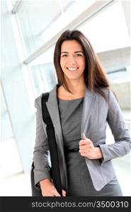 Smiling businesswoman in hall with briefcase