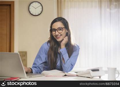 Smiling businesswoman looking at camera with hand on chin